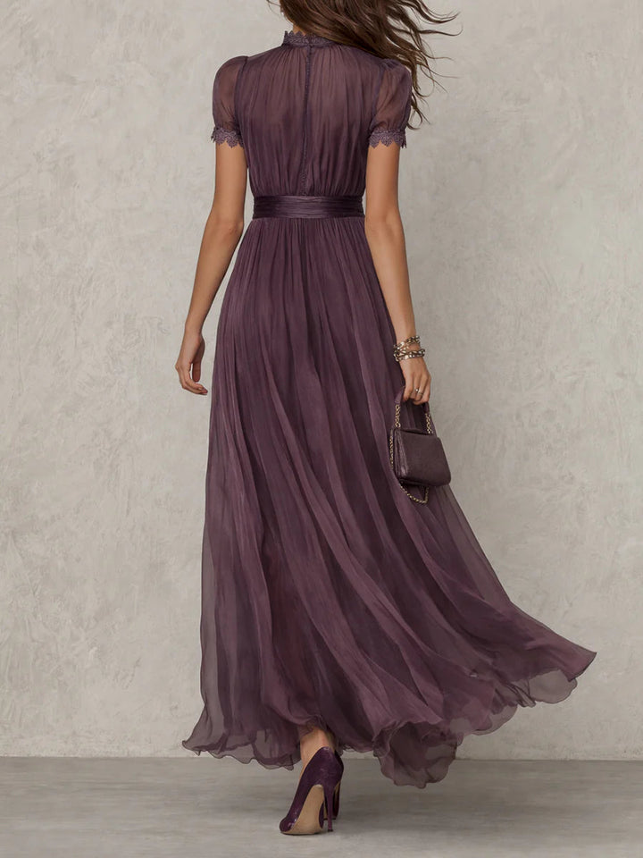 Flavia – Abito lungo viola con scollo a chiave e bordo in pizzo